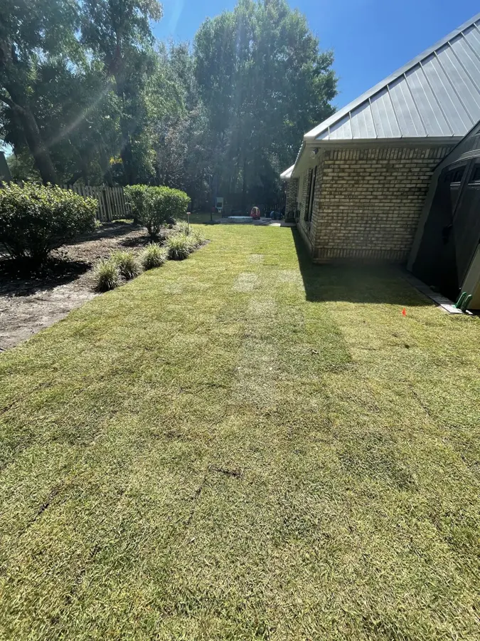 Mowed lawn beside a brick house