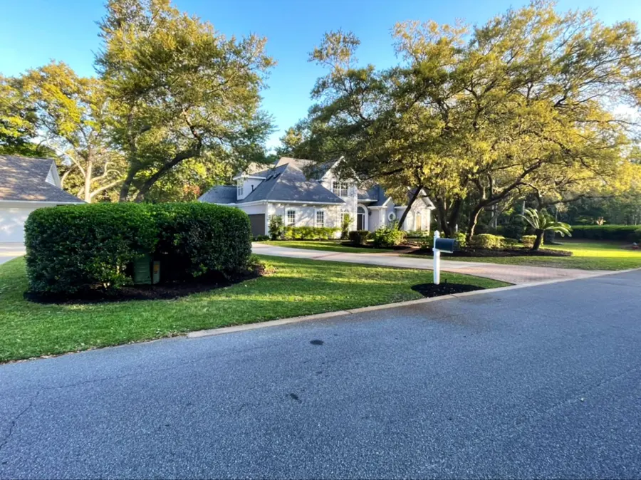 Trimmed hedge and lawn along a neighborhood street