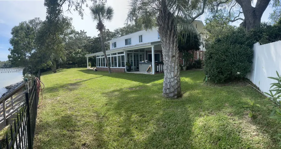 Backyard lawn beside a waterfront house